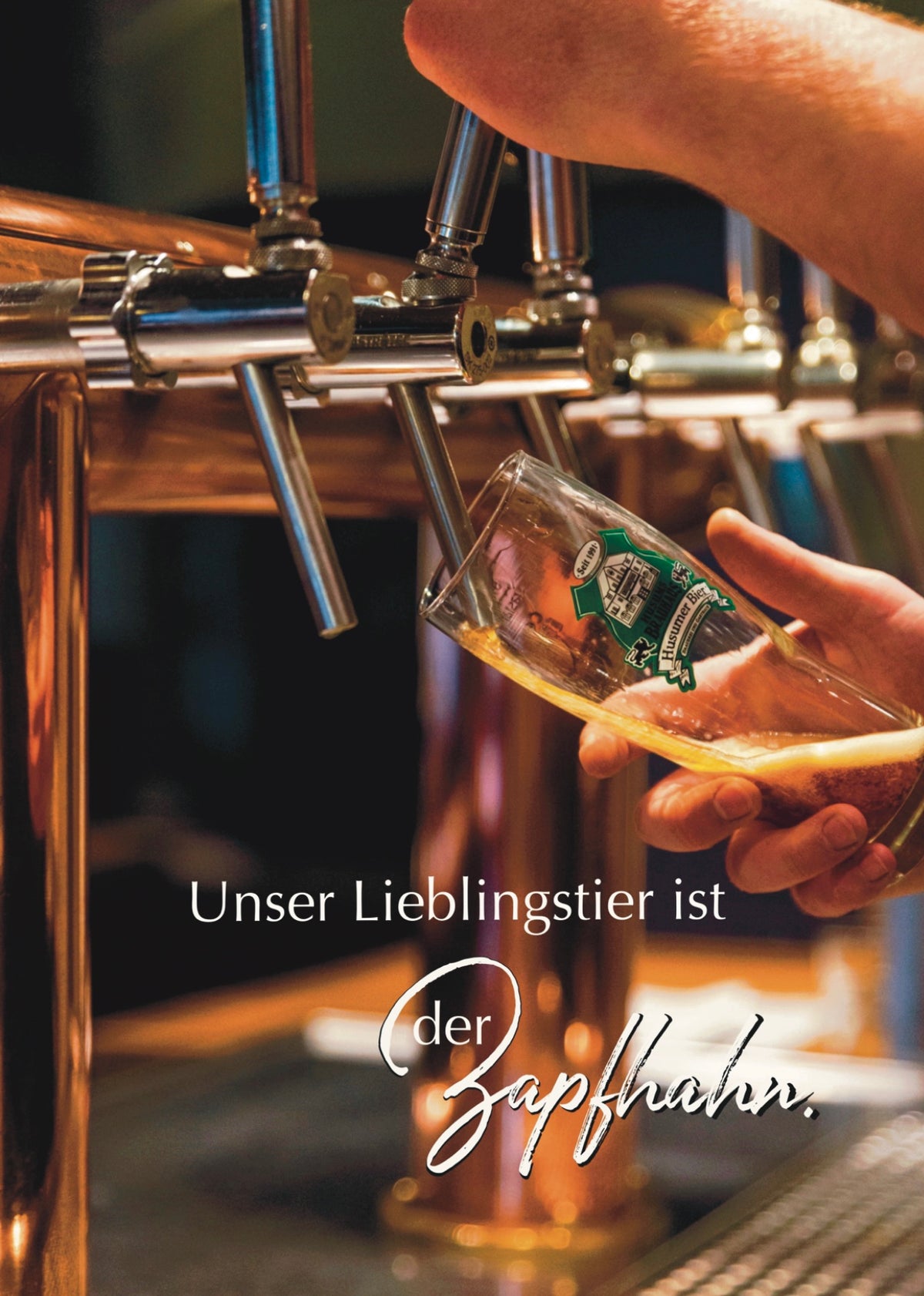 Das Foto zeigt den Zapfhahn aus dem Brauhaus. Man sieht das Glas in welches jemand das Bier zapft. Man erkennt nur die Hände die das Glas halten und den Zapfhahn bedienen. Auf dem Foto steht: Unser Lieblingstier ist der Zapfhahn.