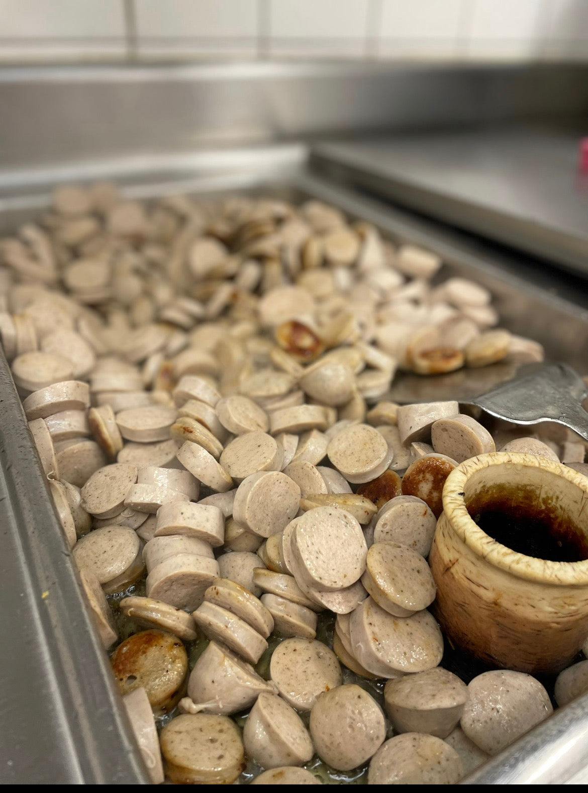 Hier sieht man den Herstellungsprozess der BierCurrywurst im Glas. Hier wird die Wurst angebraten.