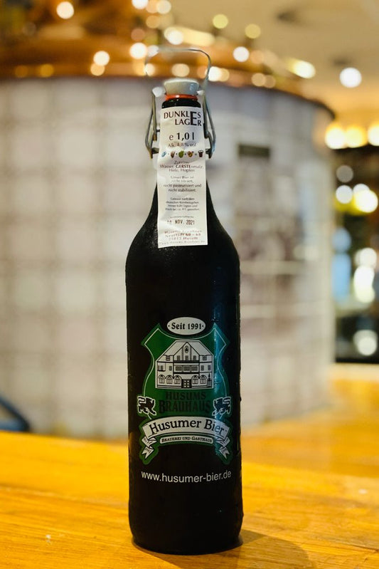 Das Bild zeigt die 1 L Ploppflasche mit Brauhaus Logo gefüllt mit Dunklem Lager.