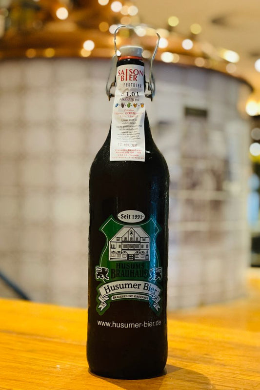 Das Bild zeigt die 1 L Ploppflasche mit Brauhaus Logo gefüllt mit SaisonBier.